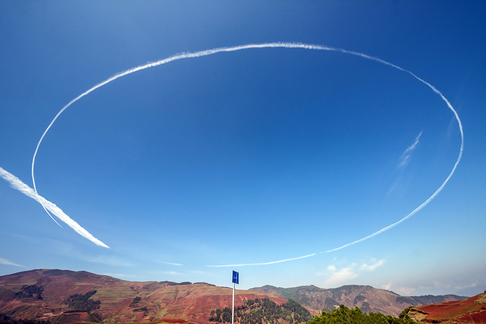 20盘旋的喷气式飞机在彝乡高空划了一个圆,这正是自然界赠送给彝乡